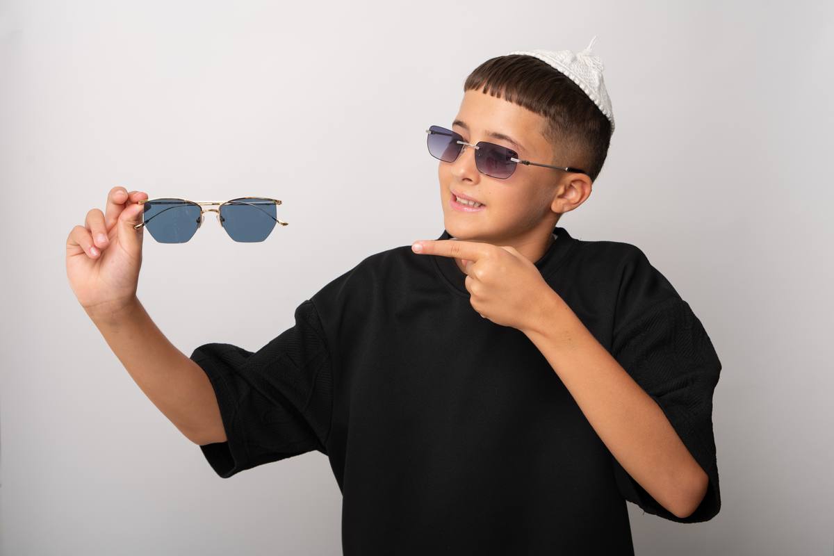 ילד מודד משקפי שמש עם הגנת UV באופטימקס נתניה